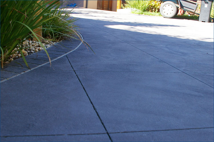 Photo of residential property with concrete drive and path leading to garage and front door.