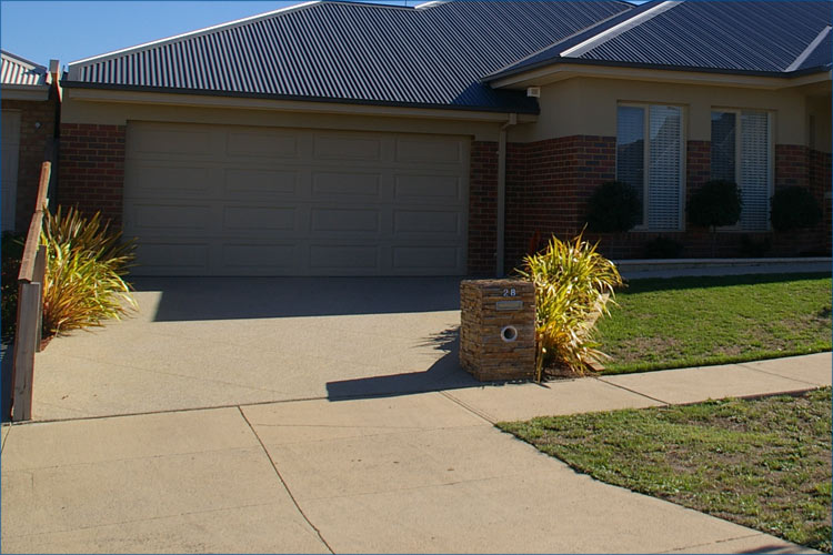 Residential property driveway with pebble concrete look.